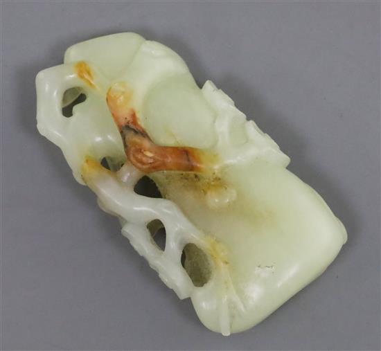 A Chinese pale celadon and russet jade carving of a prunus bough, 5.3cm